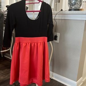 Rounded low neck dress in front and back. Empire waist. Tight fitting at top.